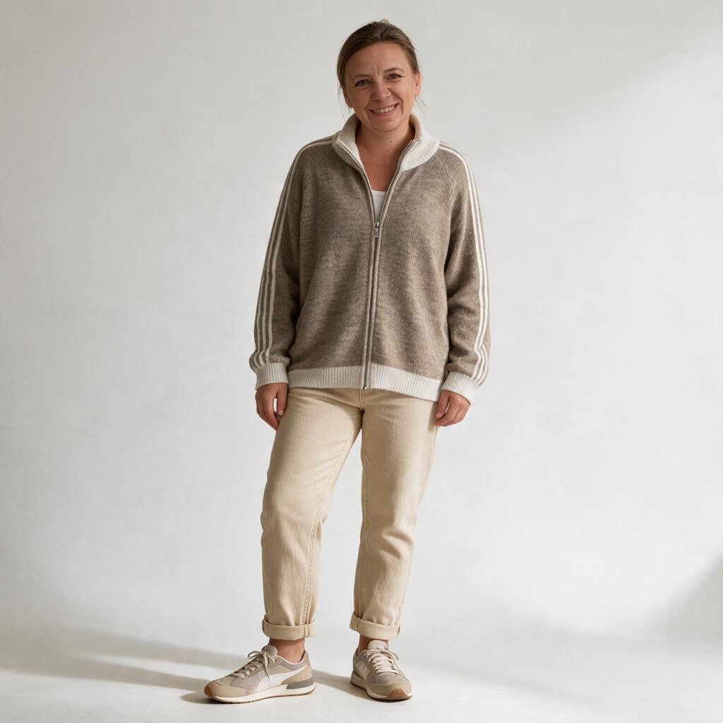 Eine Frau trägt eine beige jamalto Strickjacke mit Reißverschluss, Stehkragen und sportlichen Streifen an den Ärmeln.